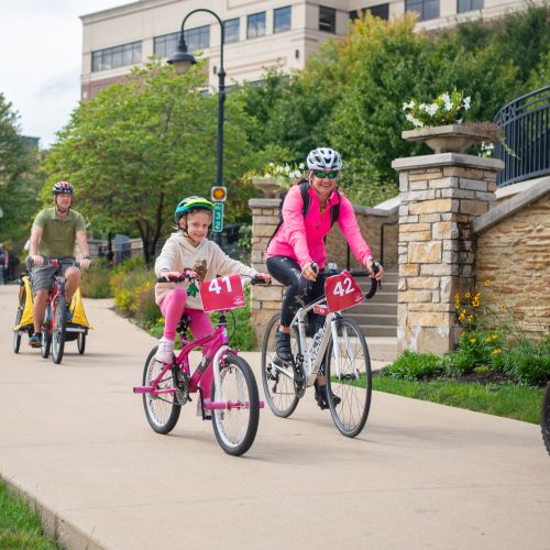 Bike riders on the path near Aurora Downtown campus