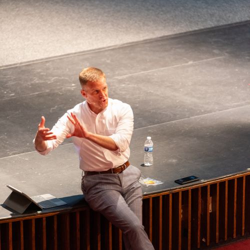 Dr. Knetl speaking on stage in front of audience