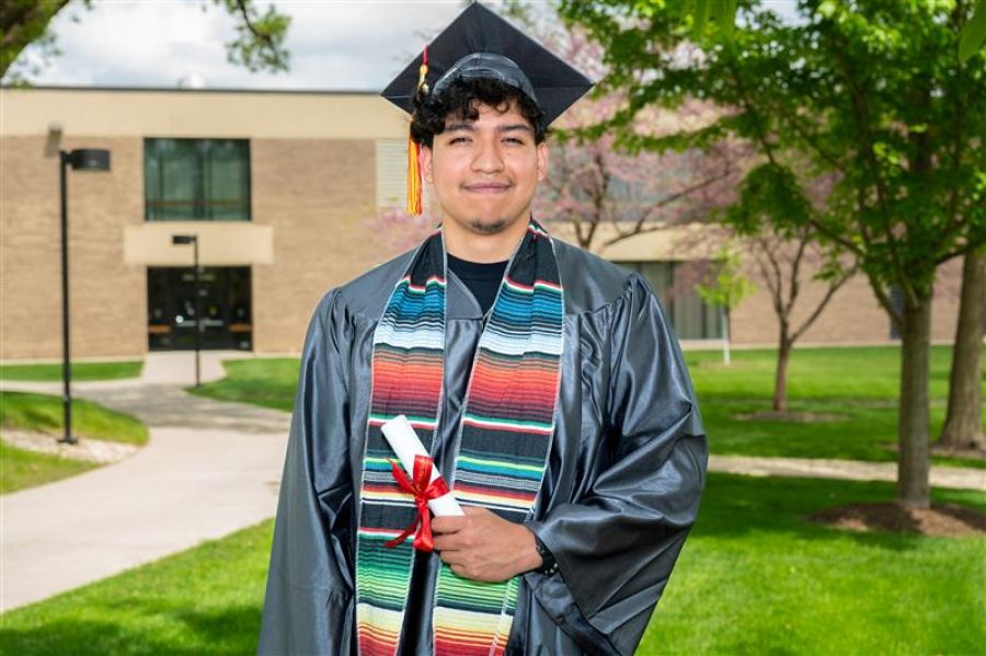 Jorge Lagunas Delgado, of Aurora Waubonsee graduate posing in cap and gown