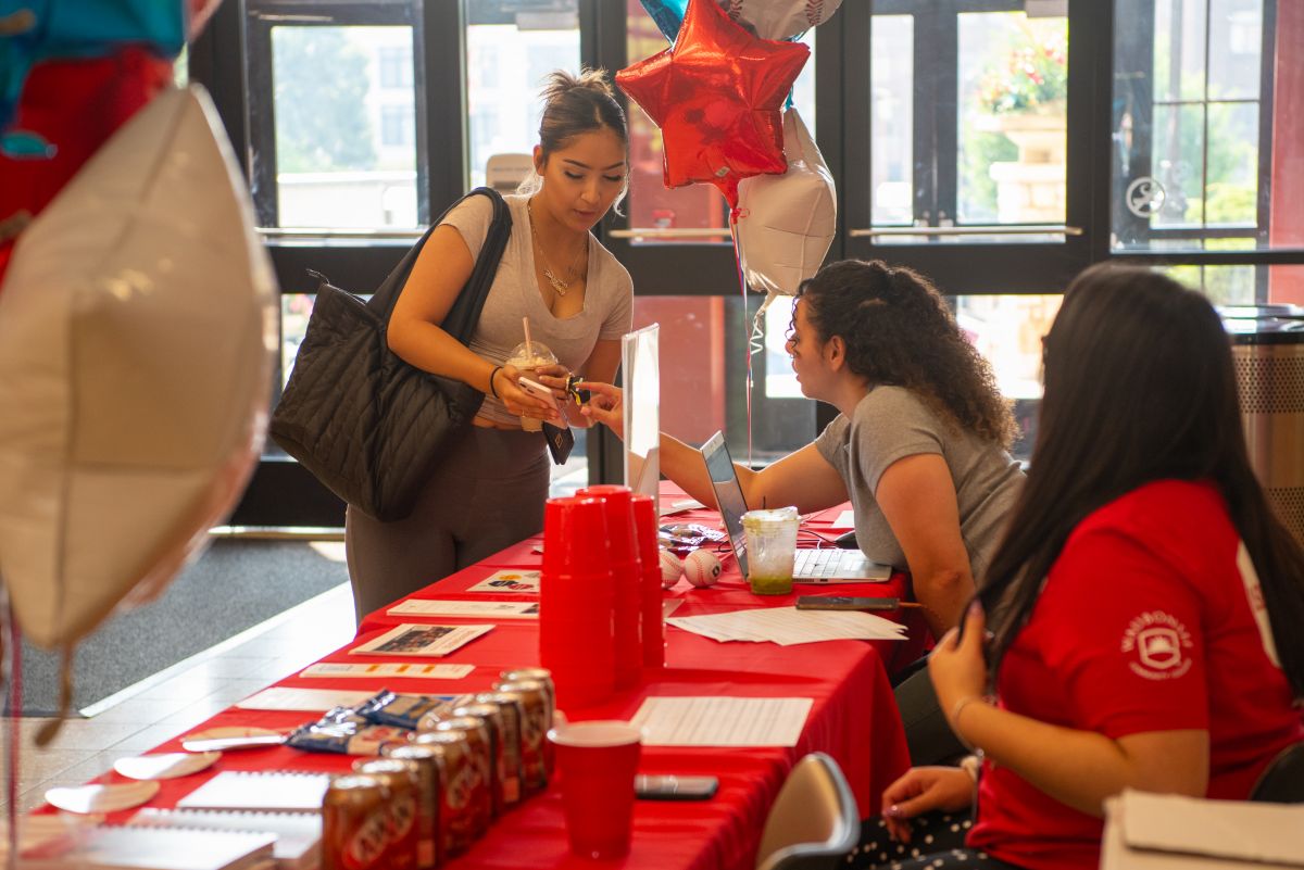 student being helped at a welcome event table