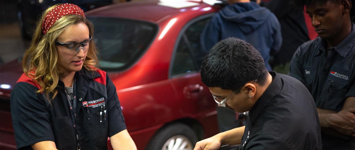 Cayla Fuechsl, Instructor of Automotive Technology, working with a student