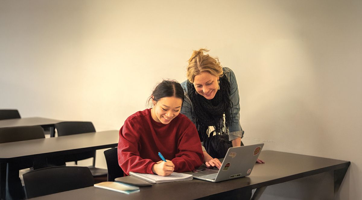 faculty member helping student at desk