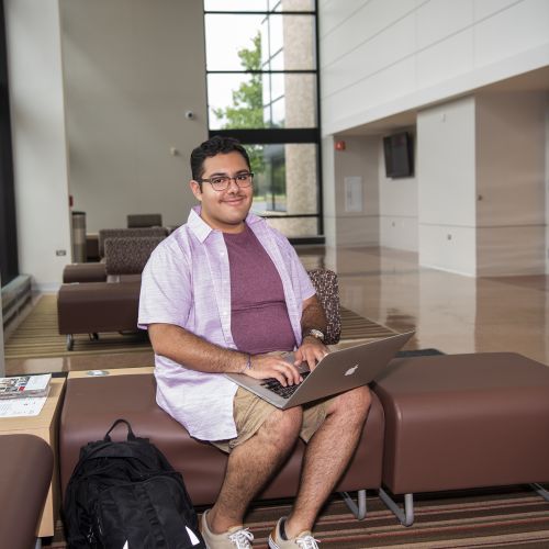 Male student working on laptop in Collins Hall