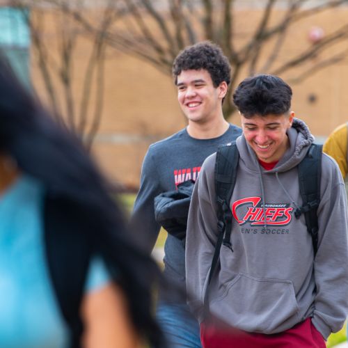 Group shot of students walking outside on campus in spring