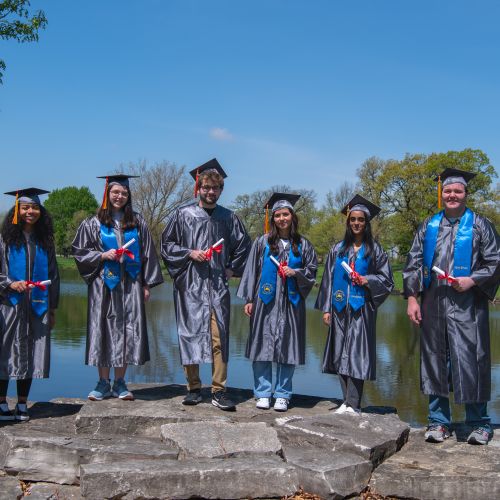 Graduates standing in front of lake huntoon