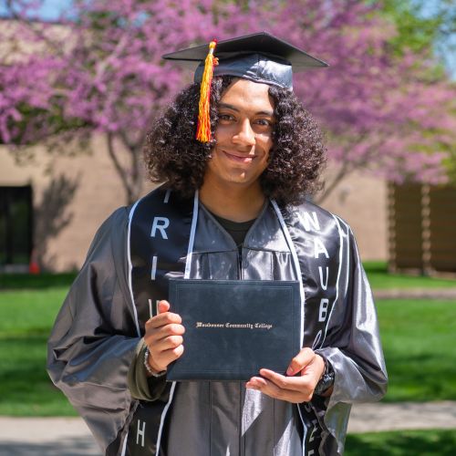 Quickpath graduate student holding degree outside