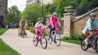 Bike riders on the path near Aurora Downtown campus