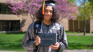 Quickpath graduate student holding degree outside