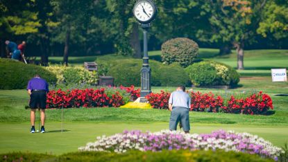 Golfers playing on the course with lots of flowers