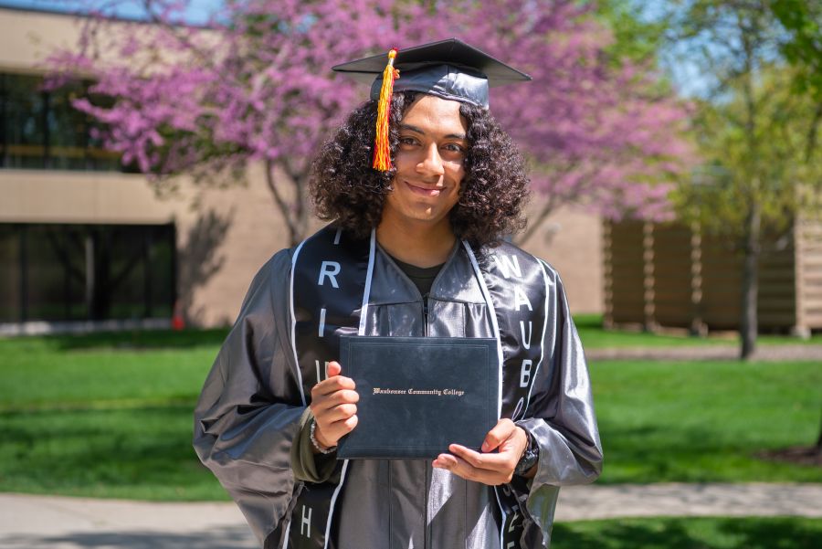 Quickpath graduate student holding degree outside